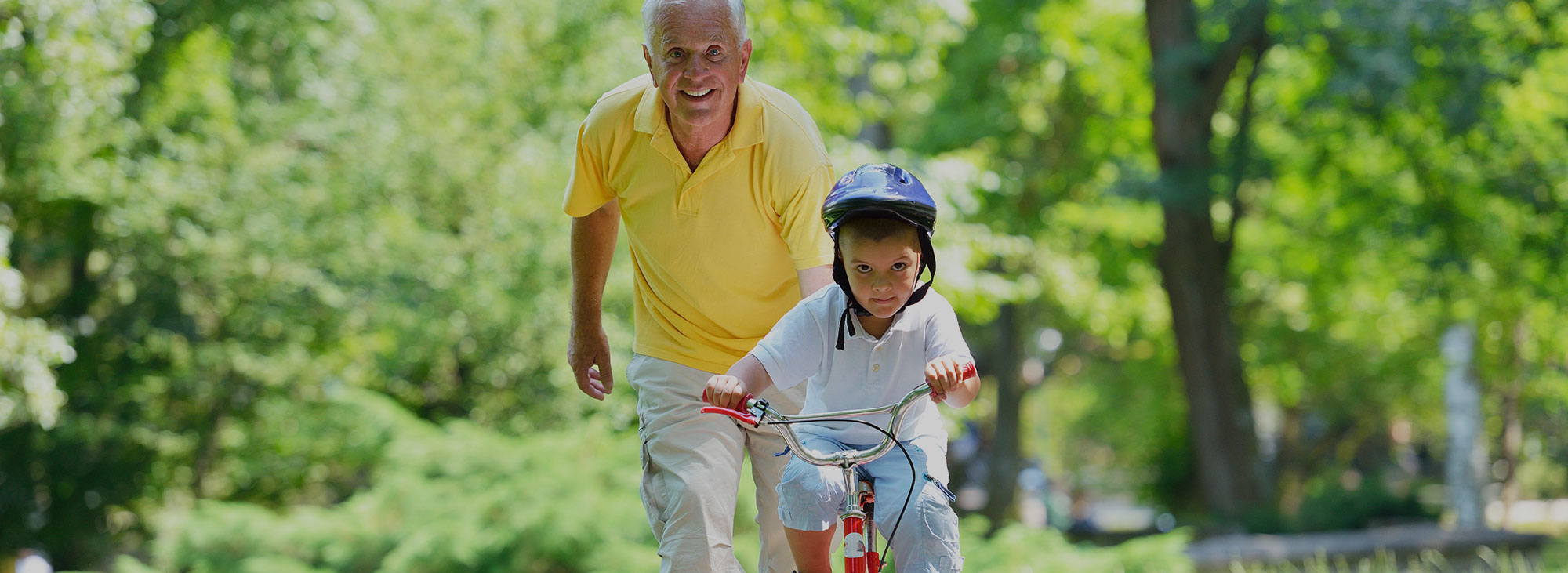 Man Helping Grandchild Ride a Bike